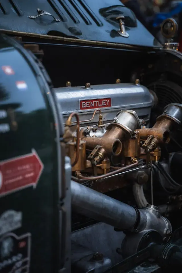 Motorruimte van een klassieke Bentley met koperen carburateurs